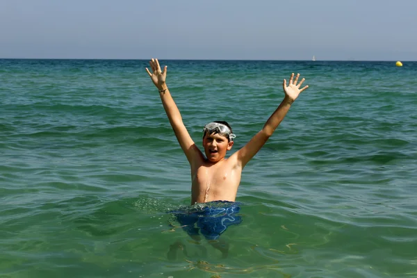 Aktiver Junge spielt mit Meerwasser. — Stockfoto