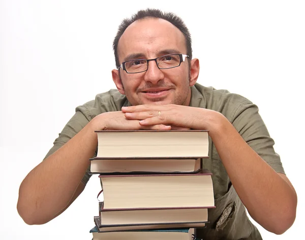 Young man leaning on stack of books — Stock Photo, Image