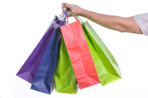 Mão masculina segurando sacos de compras coloridos — Fotografia de Stock