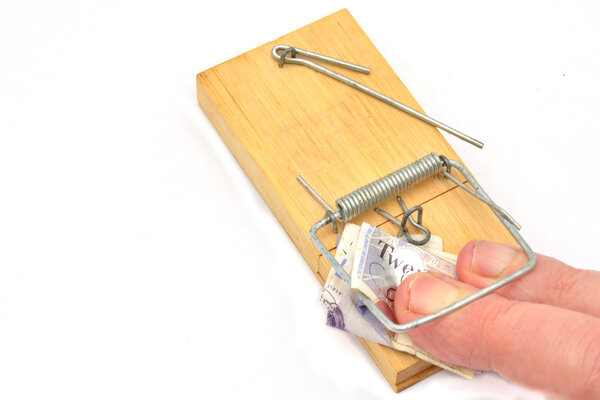 Пальцы, застрявшие в мышеловке, хватающие деньги
