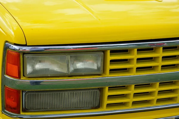 Gele voorzijde van auto met frontschijnwerpers — Stockfoto