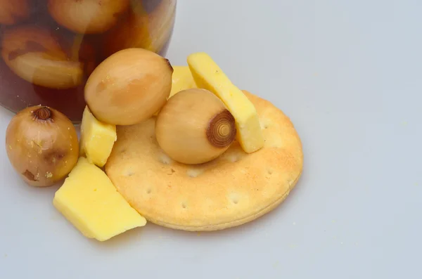 Close up van kaas koekjes en pickled uien — Stockfoto