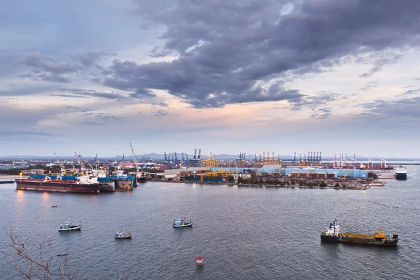 Container e gru nei cantieri navali sul mare al crepuscolo — Foto Stock