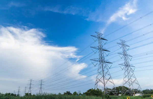 Poste de energia de alta tensão eletricidade contra o céu azul — Fotografia de Stock