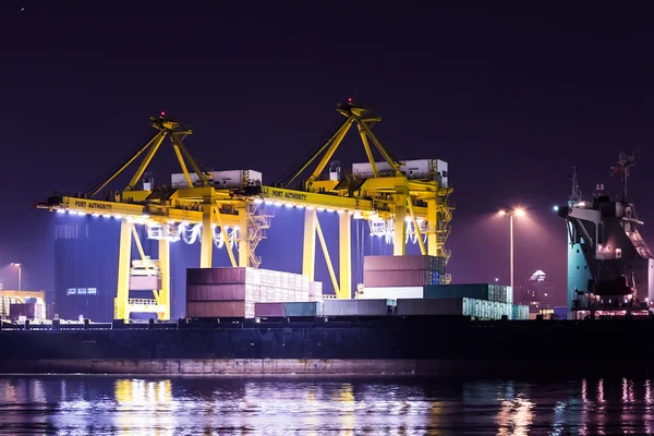 Kran arbeitet in der Abenddämmerung mit Containerfracht in Werft — Stockfoto
