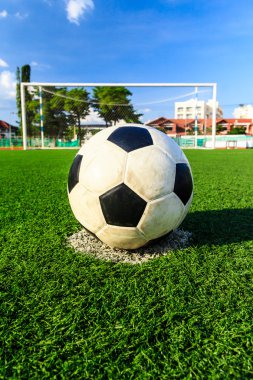 Futbol topu önünde hedefi net yeşil çimenlerin üzerinde