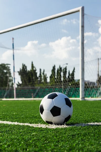Futbol topu önünde hedefi net yeşil çimenlerin üzerinde