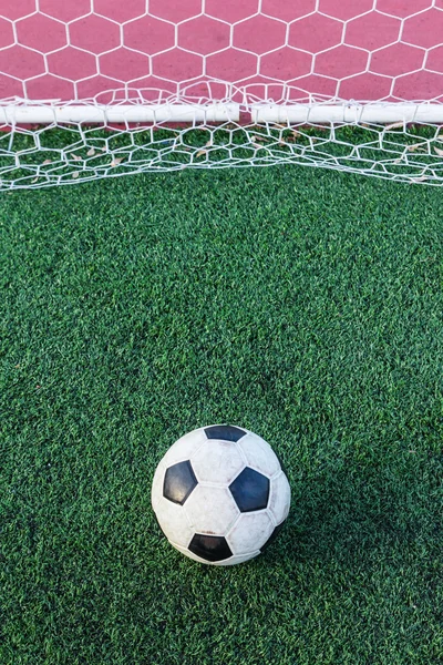Piłka na zielonej trawie w bramce netto — Zdjęcie stockowe