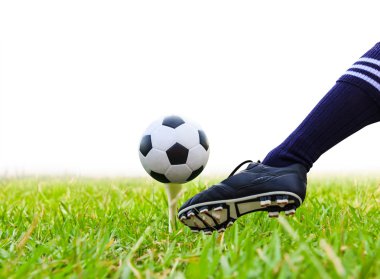foot kicking soccer ball on golf tee isolated clipart