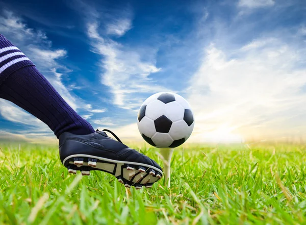 Foot kicking soccer ball on golf tee — Stock Photo, Image