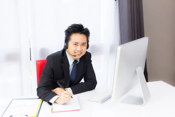 Homme d'affaires souriant travaillant avec ordinateur de bureau — Photo