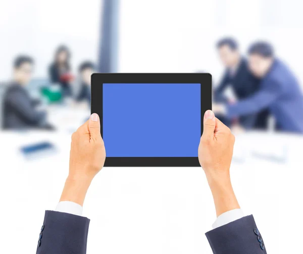 Hand som håller TabletPC med affärsmän bakgrund — Stockfoto
