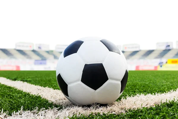 Bola de futebol no campo de grama verde isolado — Fotografia de Stock