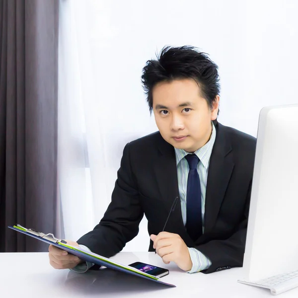 Homme d'affaires travaillant avec téléphone intelligent et ordinateur de bureau — Photo