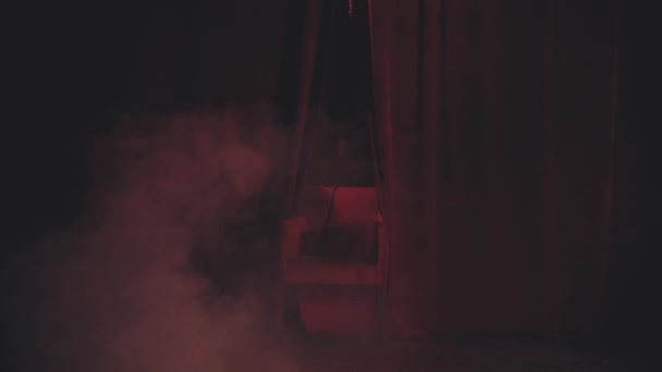 Červené křeslo na jevišti v kouři — Stock video