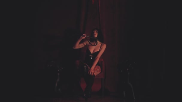 レディー・イン・ブラック座っている赤いアームチェア — ストック動画