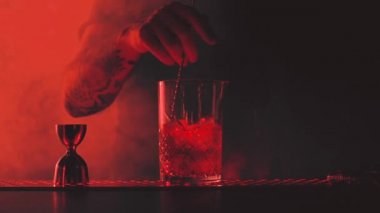 Barmen barda bir kokteyl hazırlıyor.