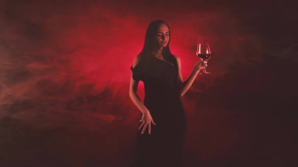 Wanita dengan segelas anggur merah dalam asap merah — Stok Video