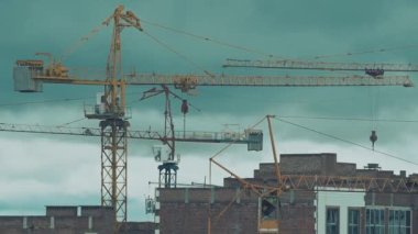 Construction of residential houses with several cranes. Time lapse