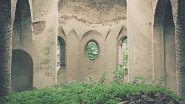 Old crumbling building overgrown with grass