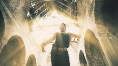 Dancing woman in light rays in castle