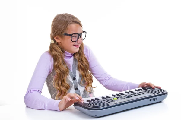 Schulmädchen spielt auf einem kleinen Synthesizer — Stockfoto