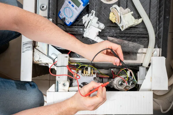男人用洗碗机零件的电检测仪测量尺寸 — 图库照片