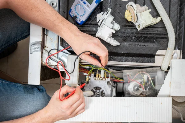 Bir Adam Bulaşık Makinesi Parçalarından Oluşan Bir Elektrikli Testçiyle Ölçü — Stok fotoğraf