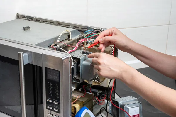 Mikrodalga Fırının Tamiri Bir Kadın Elektriksel Özelliklerini Test Edenle Ölçer — Stok fotoğraf