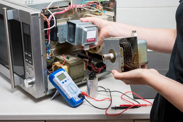 Reparación Del Horno Microondas Una Mujer Reemplaza Magnetrón Fotos de stock