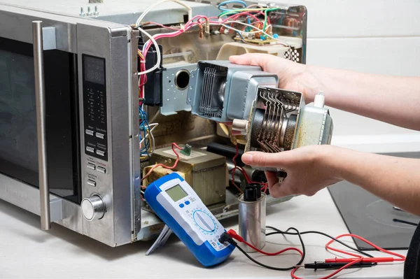 Reparación Del Horno Microondas Una Mujer Reemplaza Magnetrón Fotos de stock libres de derechos