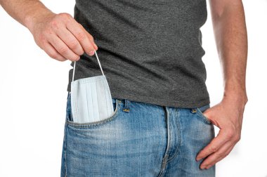 Adam, kotun ön cebinden tıbbi maskeyi çıkar.