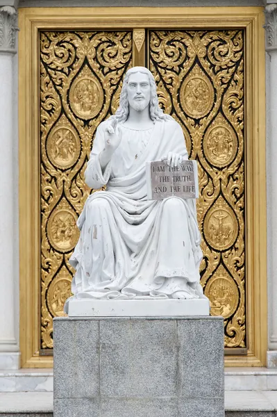Kilisenin kapısının önünde İsa heykeli — Stok fotoğraf