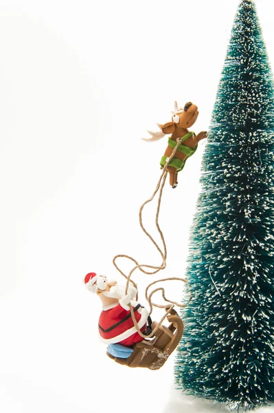 Weihnachtsmann fährt auf Schlitten am Weihnachtsbaum entlang — Stockfoto