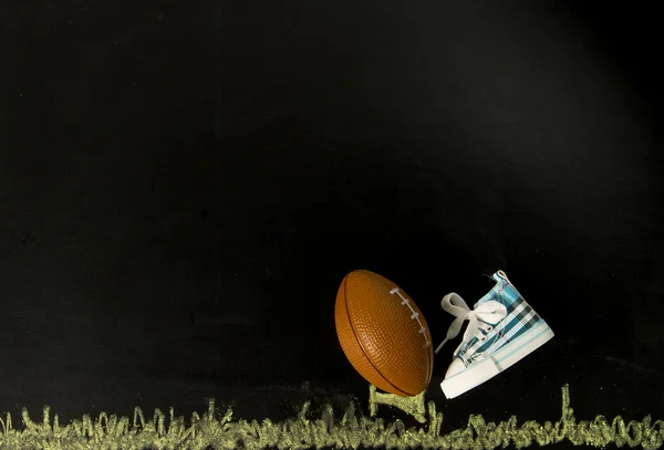 Fotboll på tee med en sko i svart bakgrund — Stockfoto