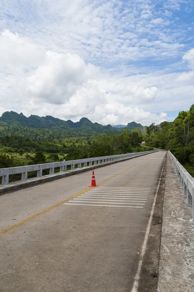 Puente largo cruza el río hacia la montaña —  Fotos de Stock