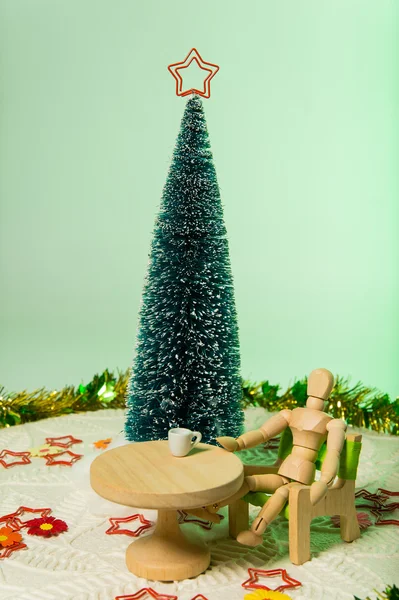 Model sit on green chair with Christmas tree isolated on soft green background — Stock Photo, Image