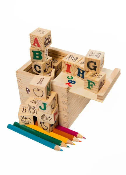 Цветной карандаш под деревянным алфавитным блоком — стоковое фото