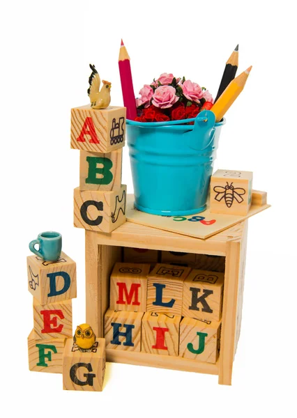 Blue bucket with color pencil on wooden alphabet block box — Stock Photo, Image