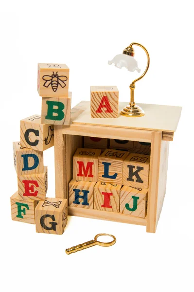 Wooden alphabet block with desk lamp and magnifying glass — Stock Photo, Image