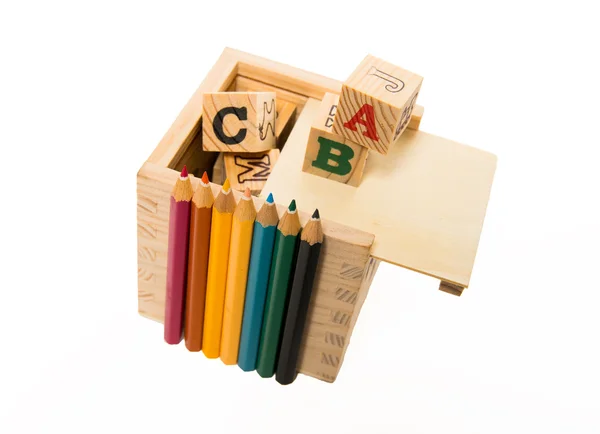 彩色铅笔排列在木制字母块框 — 图库照片