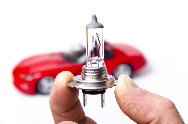 Car halogen light bulb and red car — Stock Photo, Image