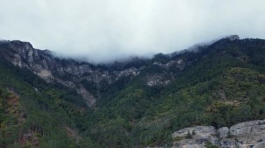 Aerial footage of rocky green forests high in the mountains 