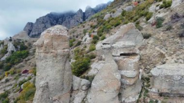 Aerial footage of mountains with rocky sculptures that are getting covered by clouds. High-quality 4k footage