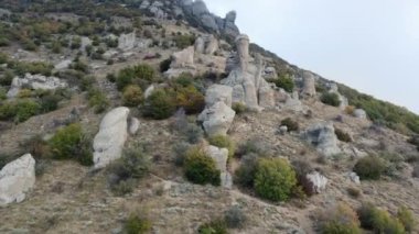 Aerial footage of mountains with rocky sculptures that are getting covered by clouds. High-quality 4k footage