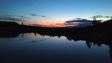 Yaz günbatımı gökyüzü. Panoramik manzara günbatımı. Vahşi doğa renkli gökyüzünde seyahat eder. Gün batımı göl sularına yansıyor.