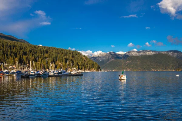Kıyı köy ve Kuzey Vancouver, bir koy ve yat limanının bir dağ sırtı zemin karşı derin Koyu'ndaki Yat Limanı ve bahar zaman mavi bir gökyüzü
