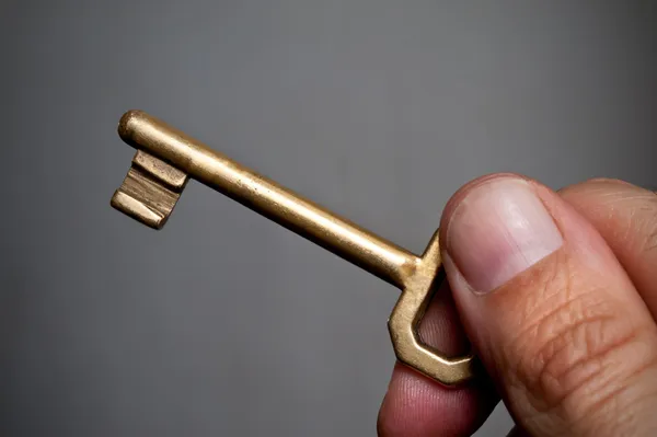 Oude sleutel in de hand. — Stockfoto