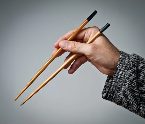 Mannenhand met stokjes — Stockfoto