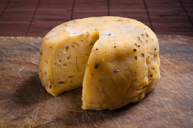 Goat cheese wheel on wooden table.